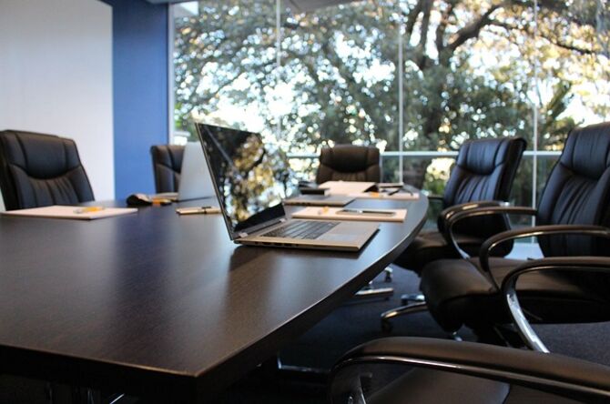 Image of boardroom empty except for a laptop