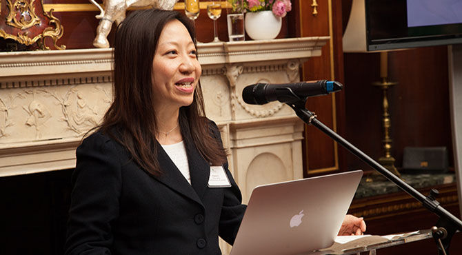 Fast forward for international education in Asia - woman speaking in front of fireplace with Apple Mac laptop