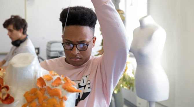 A student makes a costume at ACS Hillingdon