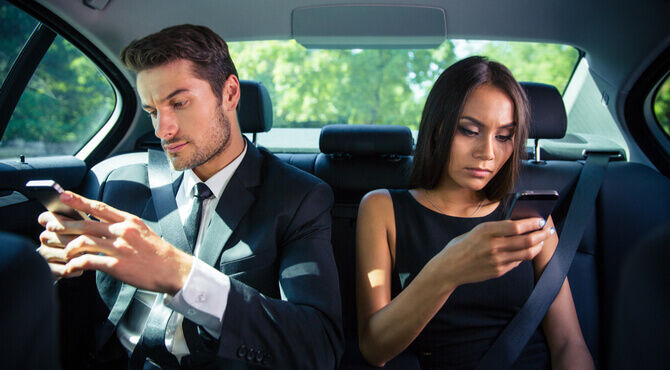 Male and female business travellers on smartphones