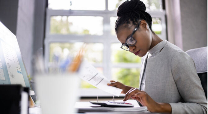 African American Accountant Or Auditor With Calculator