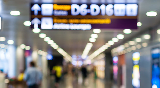 A photo of the interior of an airport in the UK, with people.