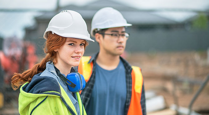 A young man and young woman apprentices on a construction job