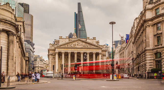 A London bus zooms past the Bank of England in London's old financial district