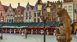 Traditional Belgian Lion Statue in front of City Hall and Colorful Brick Buildings in Market Square, Bruges, Belgium stock photo