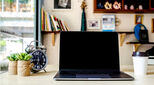 Blank working desk in home office with equipment such as laptop/notebook computer, clock, cactus tree and a cup of coffee. Work hours & lifestyle business concept