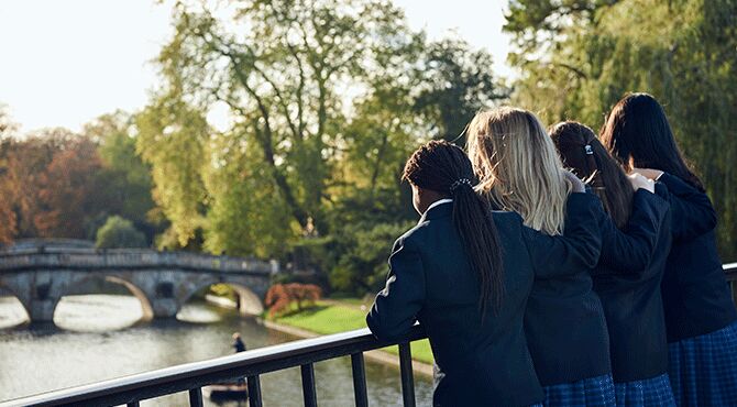 Teenage school children stand at a bridge