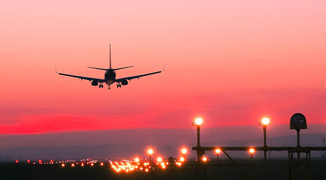 An airplane lands at sunset illustrating an article about Boeing opening a new plant in Sheffield UK