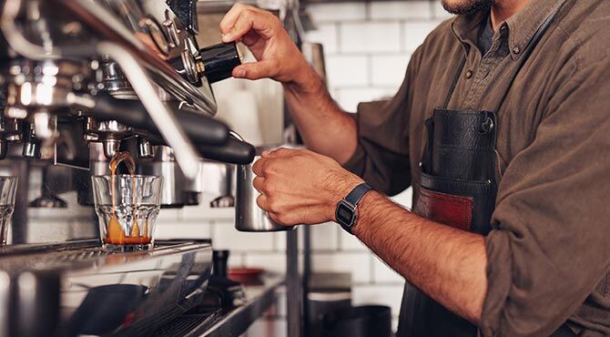 Photo of a barista making coffee illustrates an article about post-Brexit EU immigration to the UK