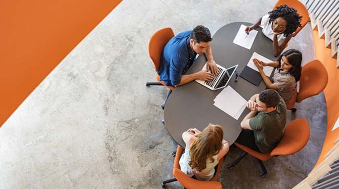 Team sitting at meeting table making business decisions