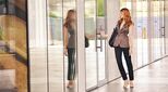 Image of woman reflected in glass opening door