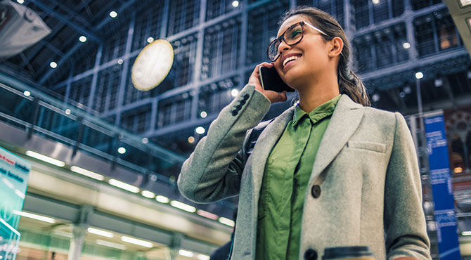 Businesswoman on her phone at a train station