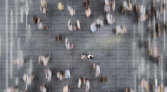 Businessman standing in the fast moving crowds of commuters. This is entirely 3D generated image.