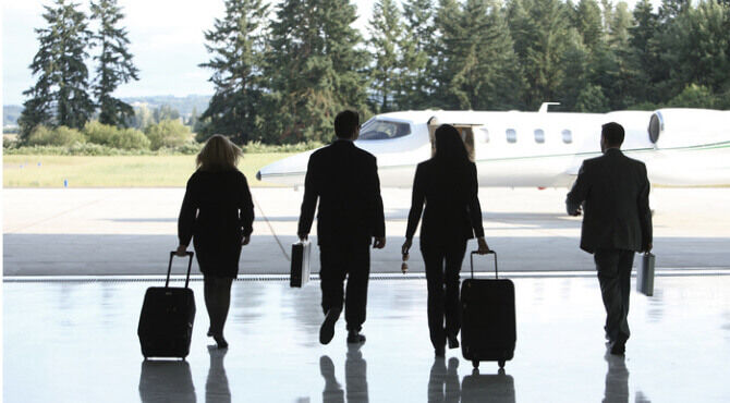 Silhouttes of business people striding out to private jet