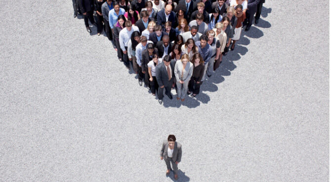 Woman in suit at apex of group of colleagues