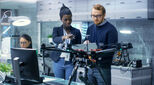 Caucasian Male and Black Female Engineers Working on a Drone Project with Help of Laptop and Taking Notes. He Works in a Bright Modern High-Tech Laboratory