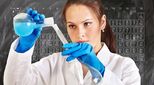 Female chemist pours liquid