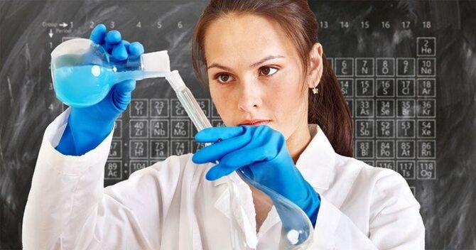 Female chemist pours liquid