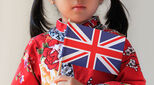Chinese child holds British flag to illustrate article about Asian scholars and researchers returning to their home lands