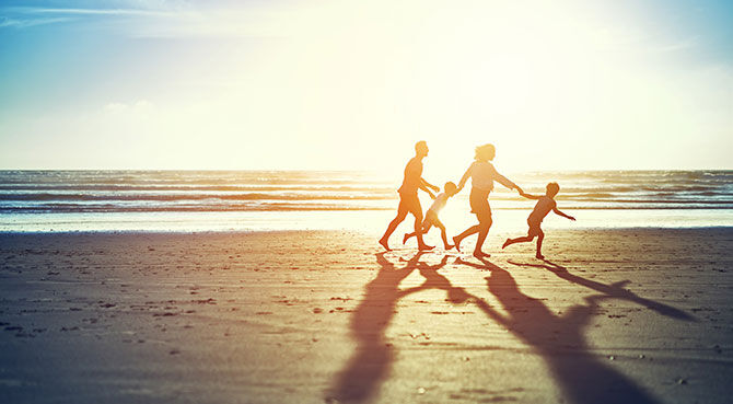 Family running along a beach