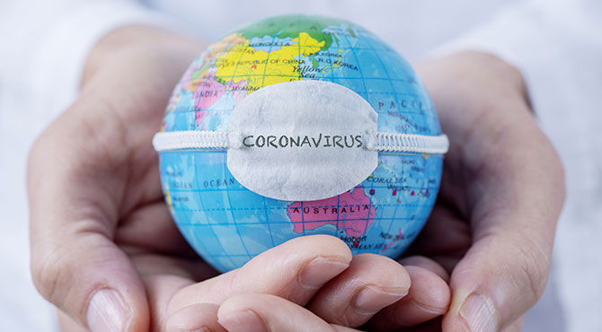 A globe encircled by hands with the word Coronavirus superimposed upon it