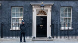 Photo of 10 Downing Street, home of the British Prime Minister, with a policeman standing guard outside