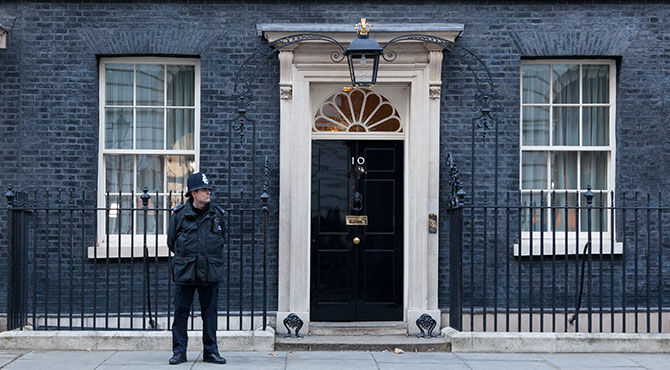 Photo of 10 Downing Street, home of the British Prime Minister, with a policeman standing guard outside