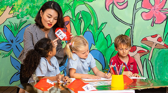 A teacher with young students at Dulwich College Singapore