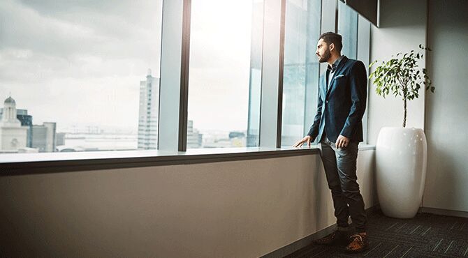 Thoughtful employee looks out of window