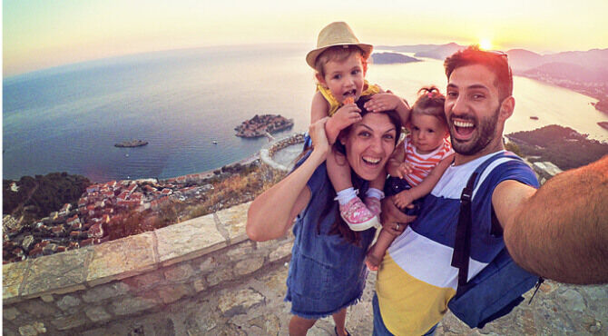 Family smiling against Seaview and taking selfie