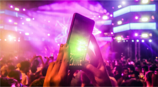Image of concert goer holding up smartphone