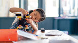 A child in a classroom constructing a scientific model