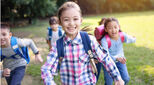 Group of elementary school kids running on the grass