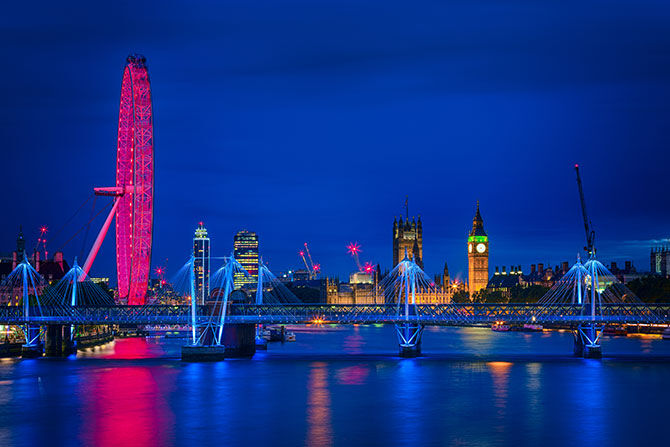 Image of the London skyline at night, featuring the Houses of Parliament and London Eye