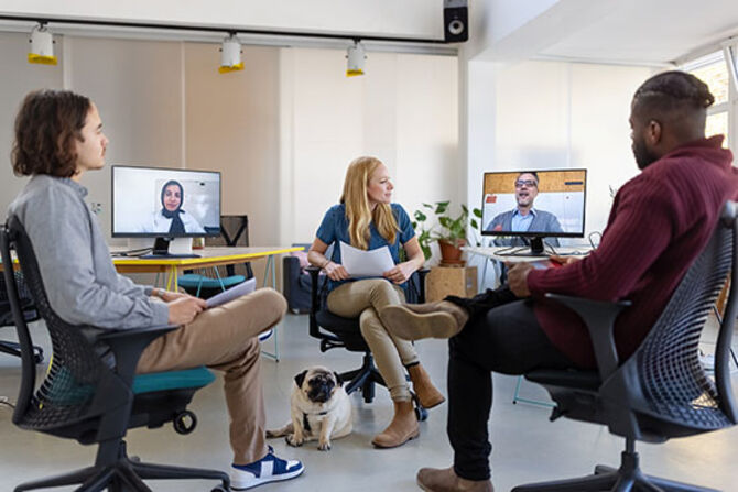 Workers in office talk to coworkers on Zoom