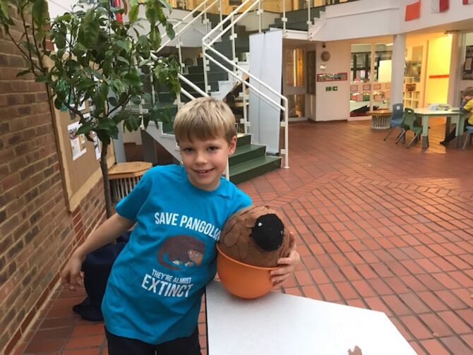 Lukas standing with Pangolin