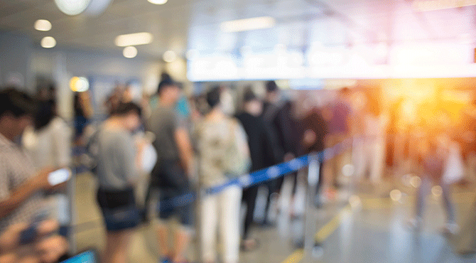 Passengers stand at airport immigration queue