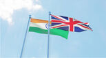 India and UK, two flags waving against blue sky