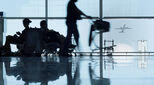 Silhouetted passengers waiting or delayed at an airport terminal in Barcelona, Spain