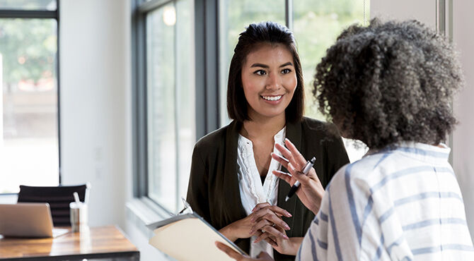 female-manager-gives-praise-to-a-smiling-mid-adult-female-employee