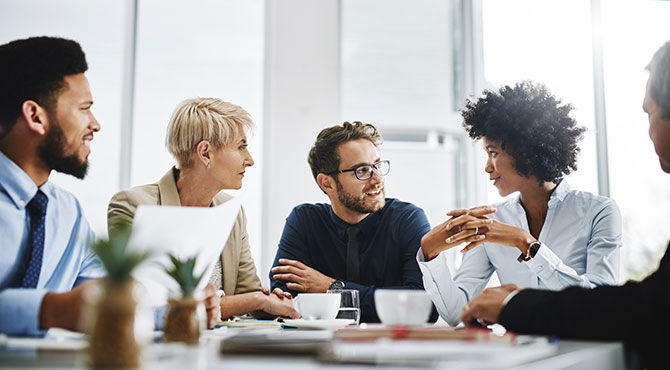 Cropped shot of a diverse group of businesspeople sitting together and having a meeting in the office