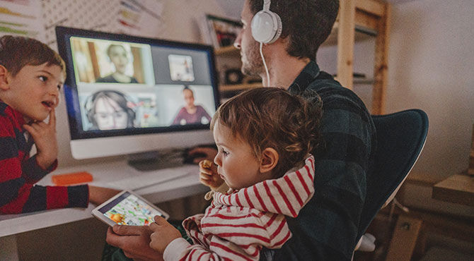 A man on a Zoom call with two children at home