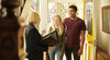 Couple with estate agent looking happy in house