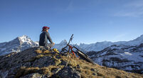 He looks off to sun shining over distant Swiss Alps