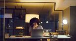 Image of woman at desk with head in hands