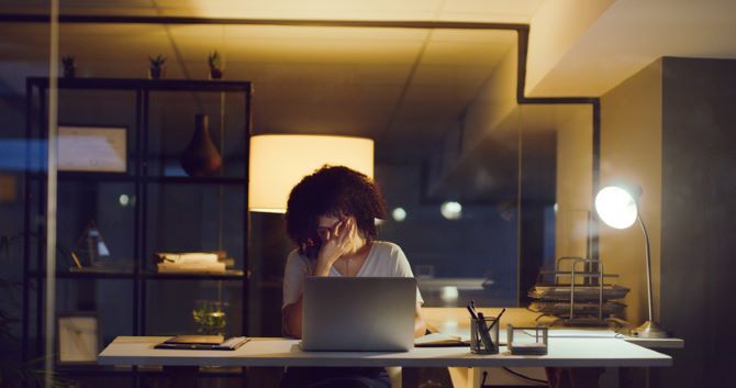 Image of woman at desk with head in hands