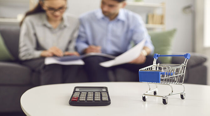 calculator and shopping basket with couple in background