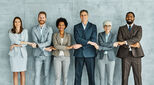 Portrait of a group of young and senior business people holding hands together in the office. Teamwork and success concept