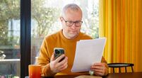 Image of man with paperwork and phone