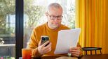 Image of man with paperwork and phone